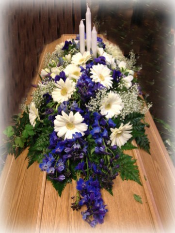 Dekoration med vita gerbera, blå iris och brudslöja samt 3 vita kronljus