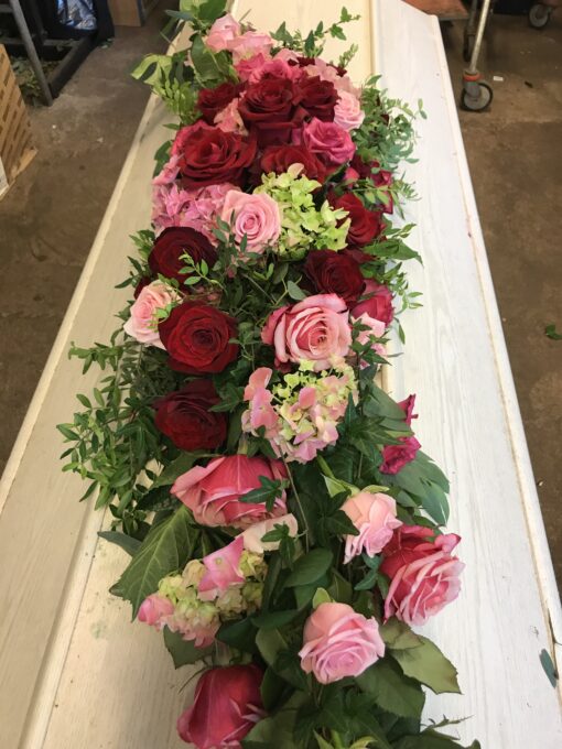 Droppformad dekoration i röda och rosa toner